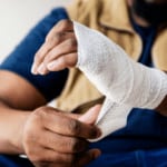 A person wraps their injured hand.