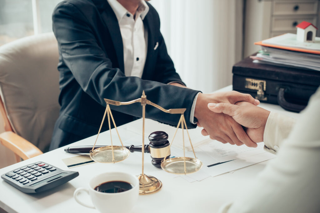 Attorney at Desk Shaking Someones Hand