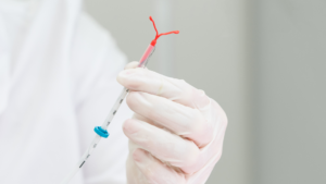 Gloved hand holding an IUD
